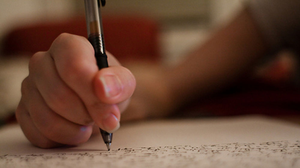Hand som skriver text med penna